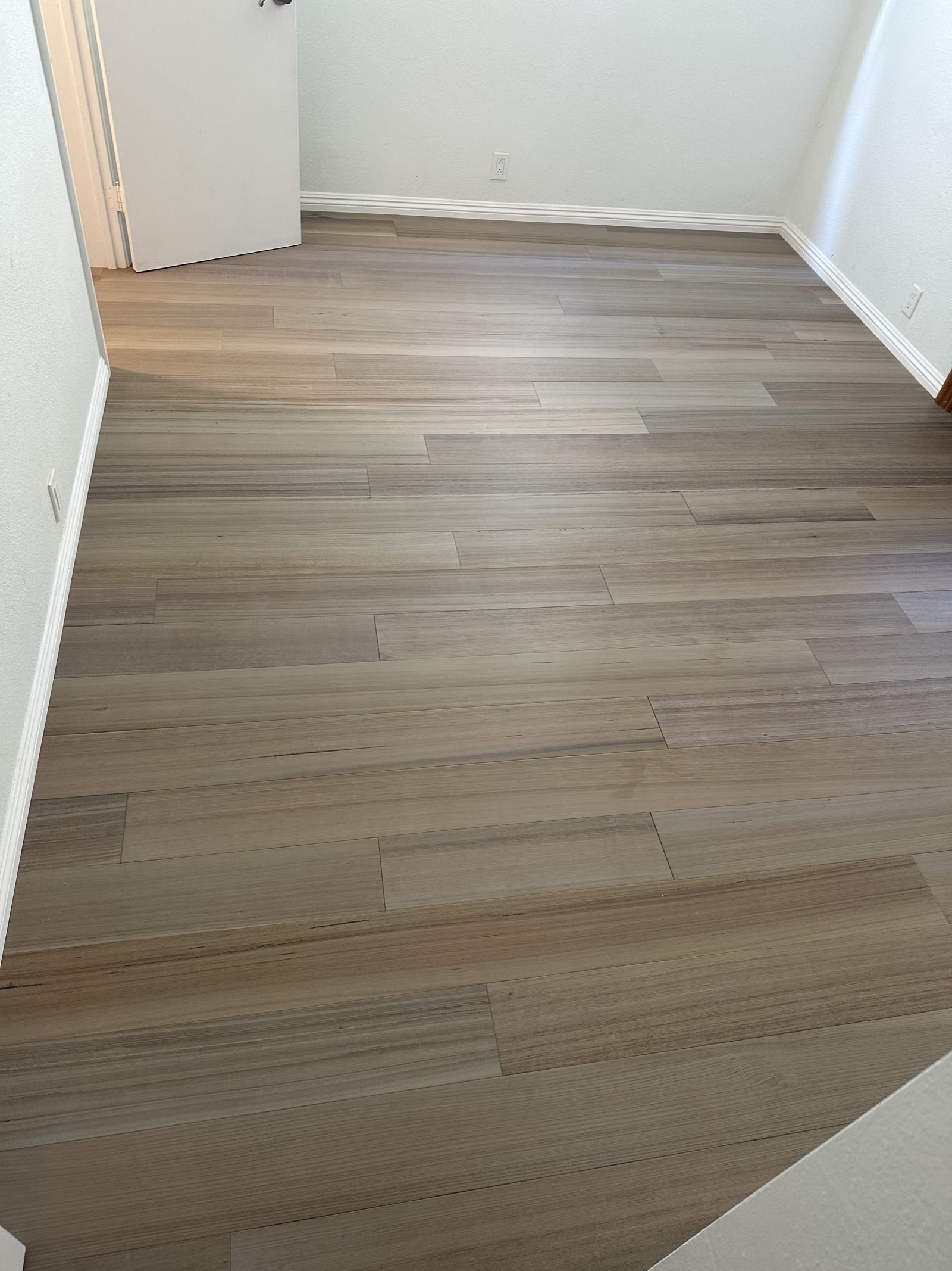 Gray-taupe luxury vinyl plank floor in an empty San Diego bedroom
