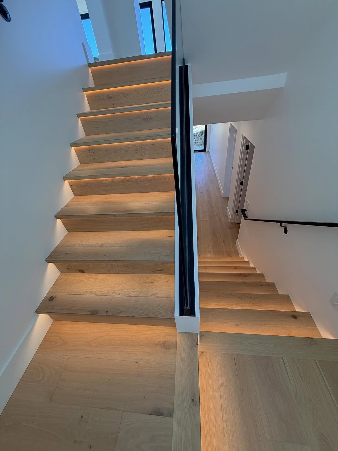 Custom hardwood stair installation with LED lighting by Top Tier Custom Floors